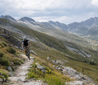 Cyclist riding a rugged mountain trail in outdoor sports sunglasses