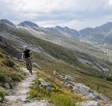 Cyclist riding a rugged mountain trail in outdoor sports sunglasses
